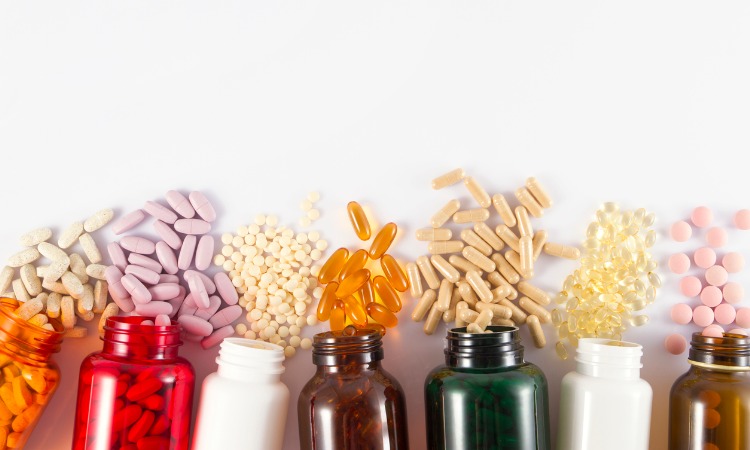 Multicolored pill bottles with different prescription drugs spilling out of each