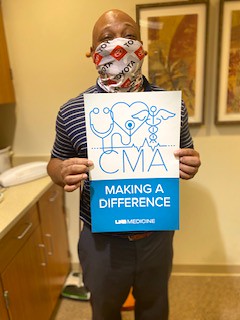 African American male holding up a poster that says "CMA: Making a Difference"