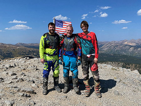 Three men standing on a mountain