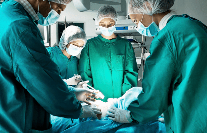 Nurses and doctors in green scrubs performing transplant operation