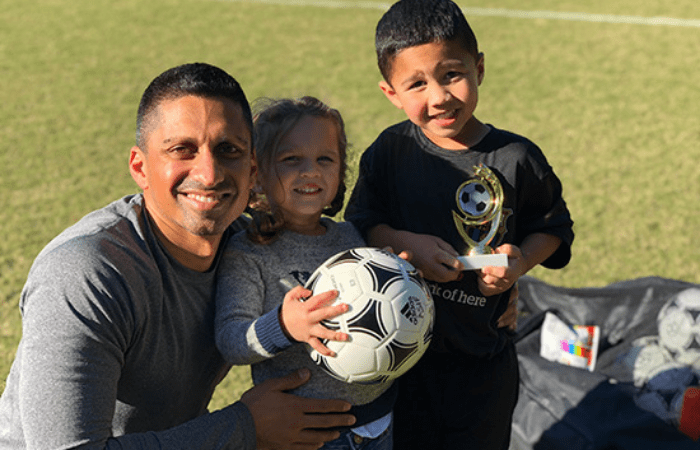 Irfan Asif, M.D., with his children outside holding a soccer ball