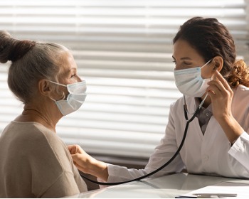 Doctor using a stethoscope on an elderly patient