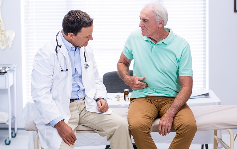 Doctor with elderly male patient discussing digestive health