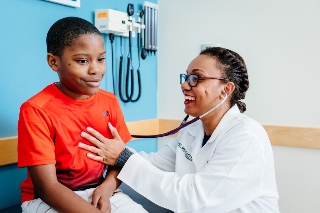 Unidentified black female pediatric doctor is examining a black male pediatric patient at the UAB Pediatric Primary Care Clinic, 2019.