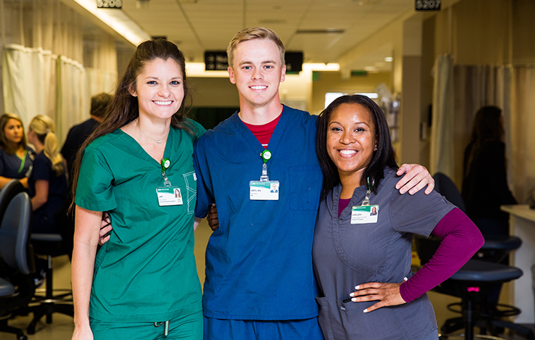 Three UAB Medicine nurses smiling and posing for a group photo