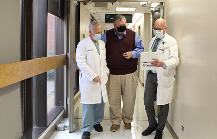 Two doctors talking with diabetes patient in hallway