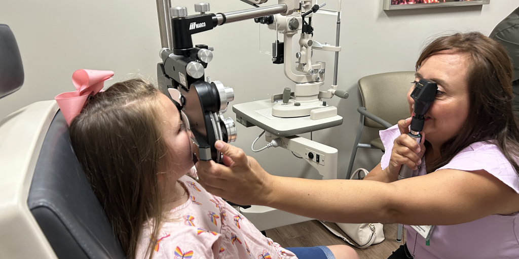 Female eye doctor examining pediatric patient's eyes