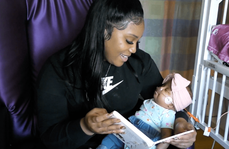women reading to newborn as part of the UAB Medicine NICU Bookworms reading program