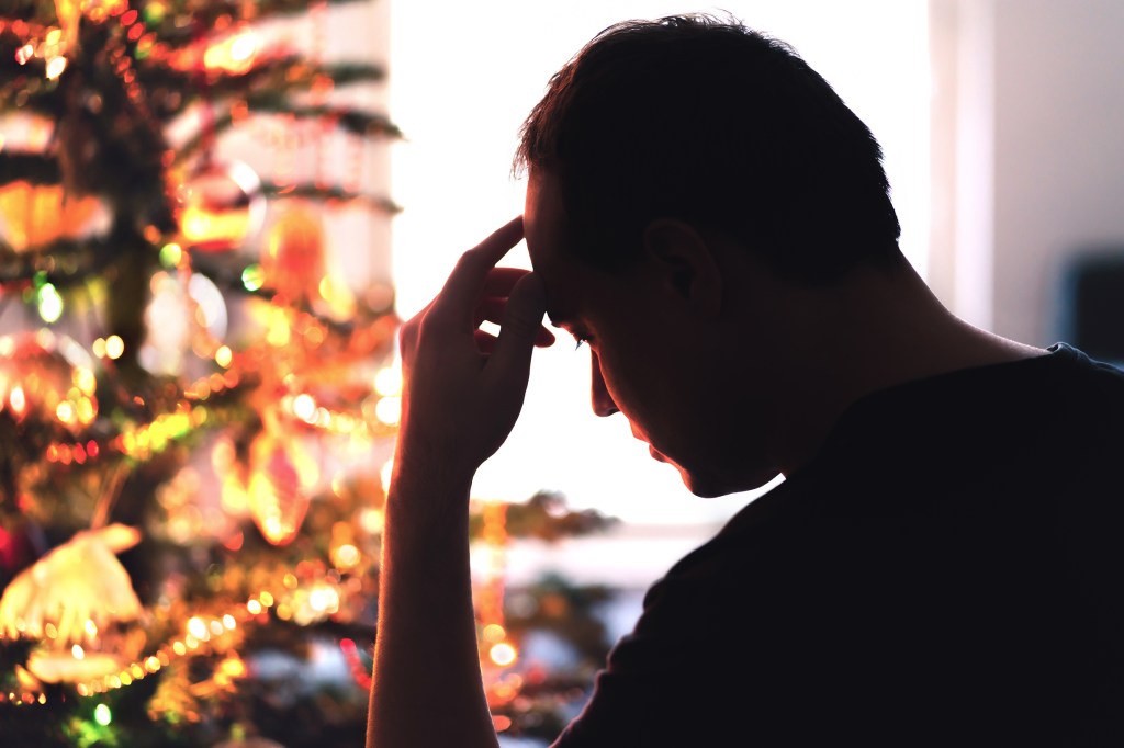 Unhappy, lonely or tired man with stress, grief or depression during the holidays.