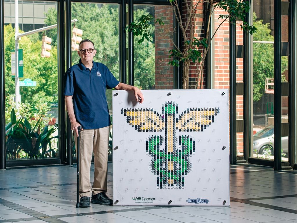 UAB patient Ruben Vuittonet Jr. posing with his origami artwork