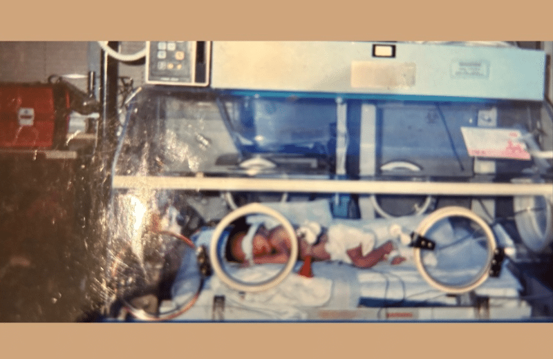Andrea Blizzard, RN, MSN, as an infant in a nicu incubator