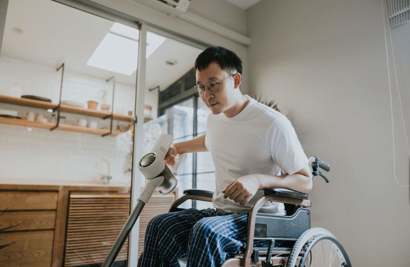 image of disabled man in a wheelchair cleaning his home