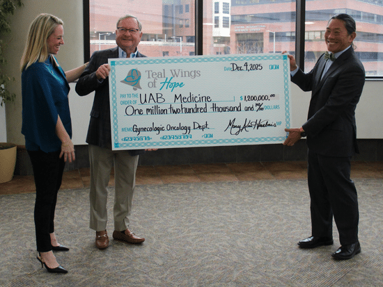 Warner Huh, M.D., presenting a large check addressed to teal wings of hope to two other individuals