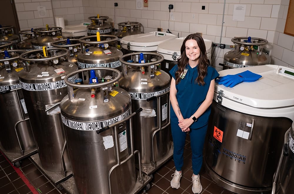 Cellular Therapy Laboratory Supervisor Amber McKell, M.S., MLS (ASCP) with nitrogen cooling tanks used to store CAR-T cells before they are transplanted in patients.