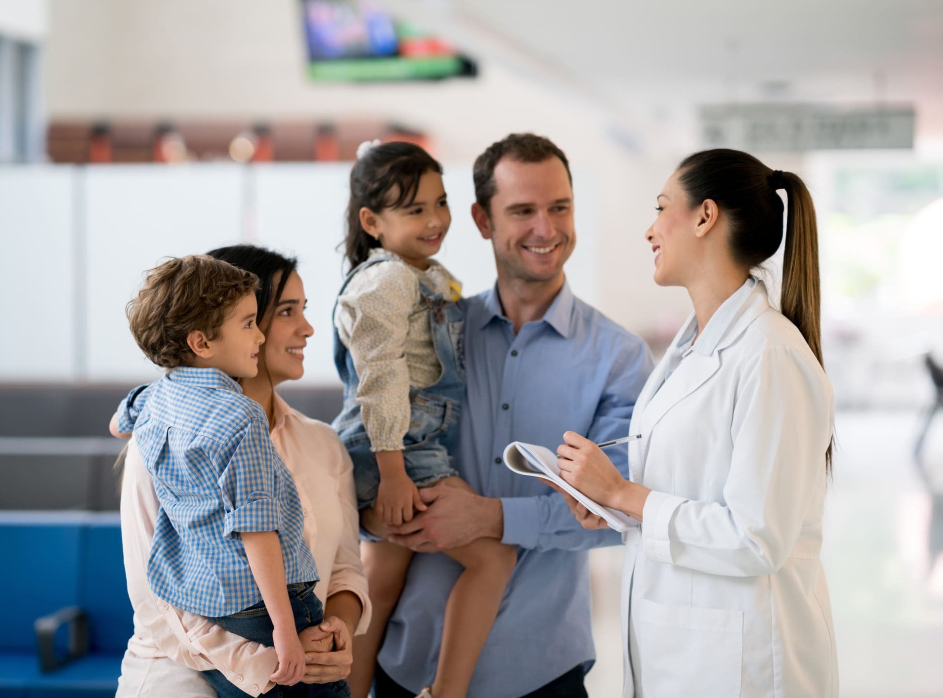 Doctor talking to a happy Latin American family in a medical facility
