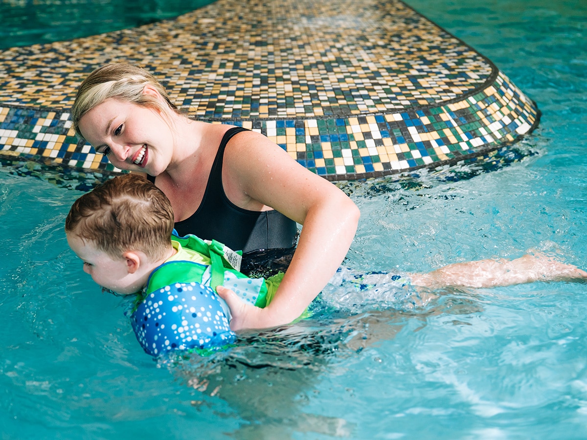 woman helping a child swim