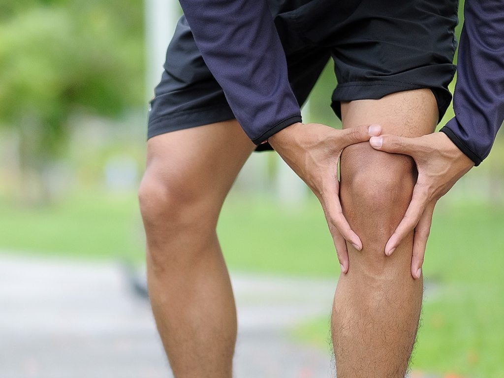 man holding his knee in pain