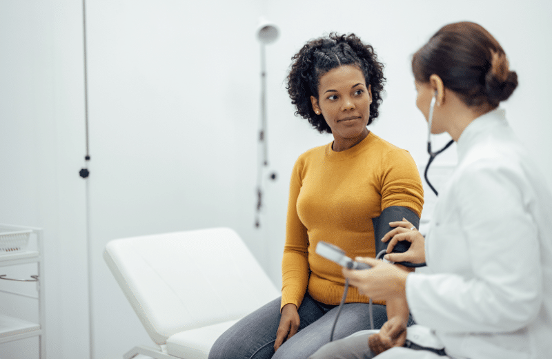 Woman discussing uterine fibroids with a female doctor