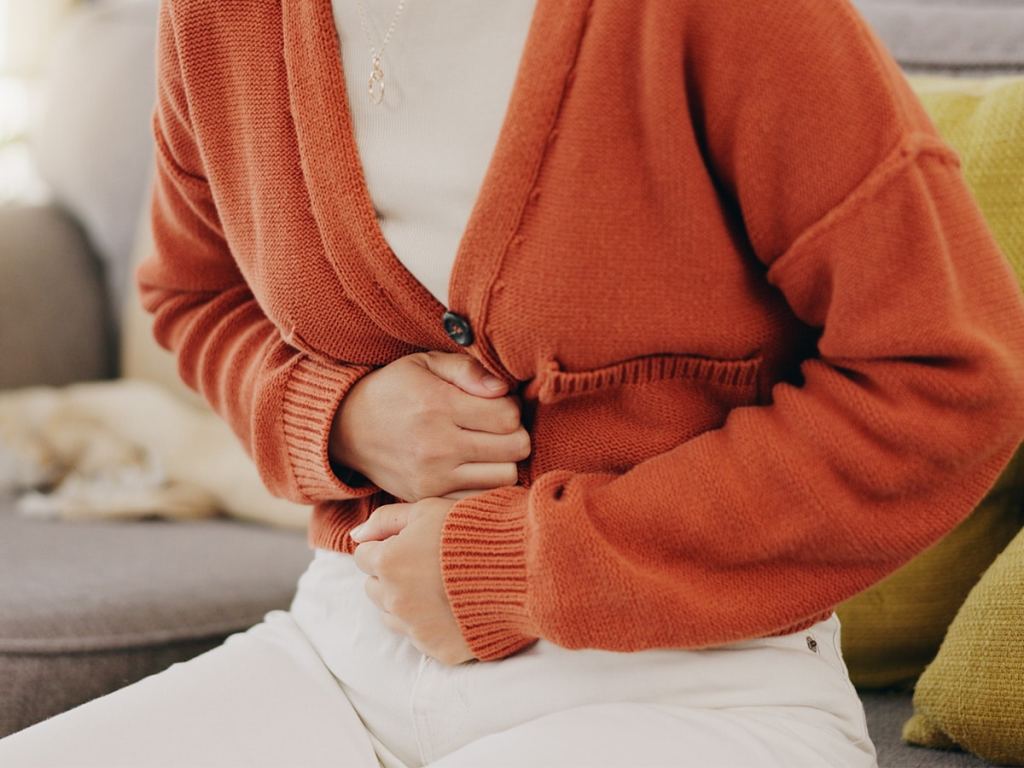 woman clutching her abdomen in pain